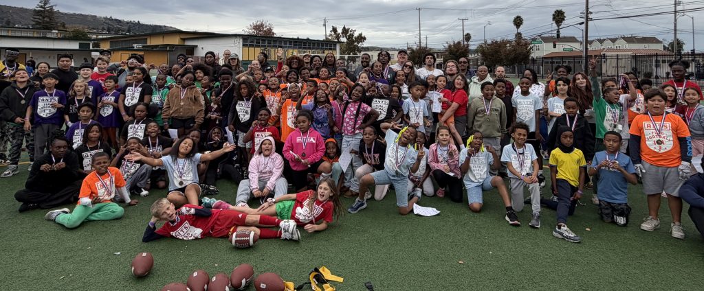 Children, coaches and families gathered on a field for an ANTS flag football event.